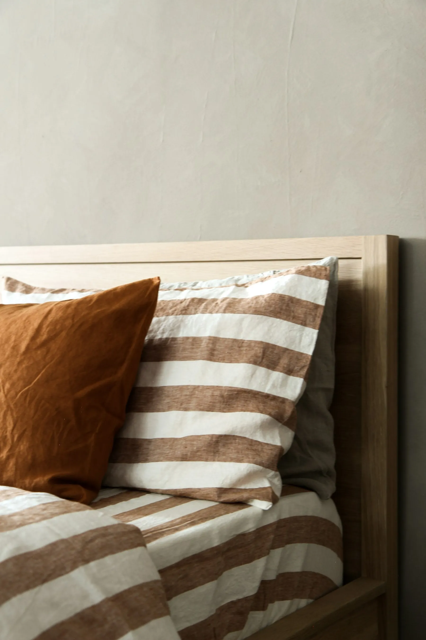 Neatly made bed with linen bedding, a calm still-life detail